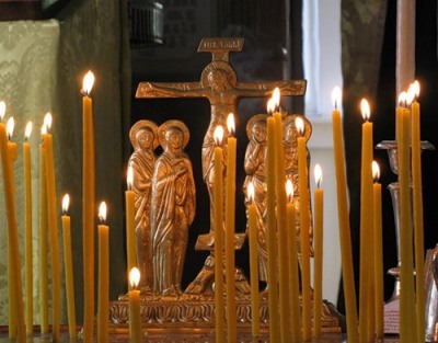 Запаљене свеће испред крста